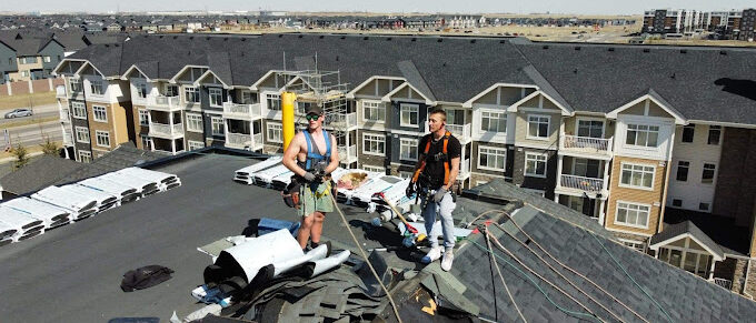 2 roofers onto of a roof in a subdivision in North Bay